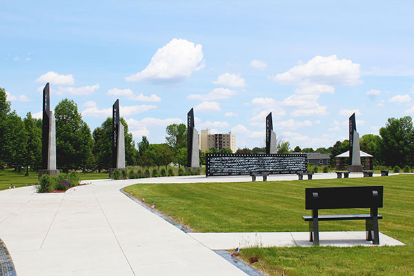 Veterans Memorial Park in Grand Forks — service-branch monuments along a curved walkway